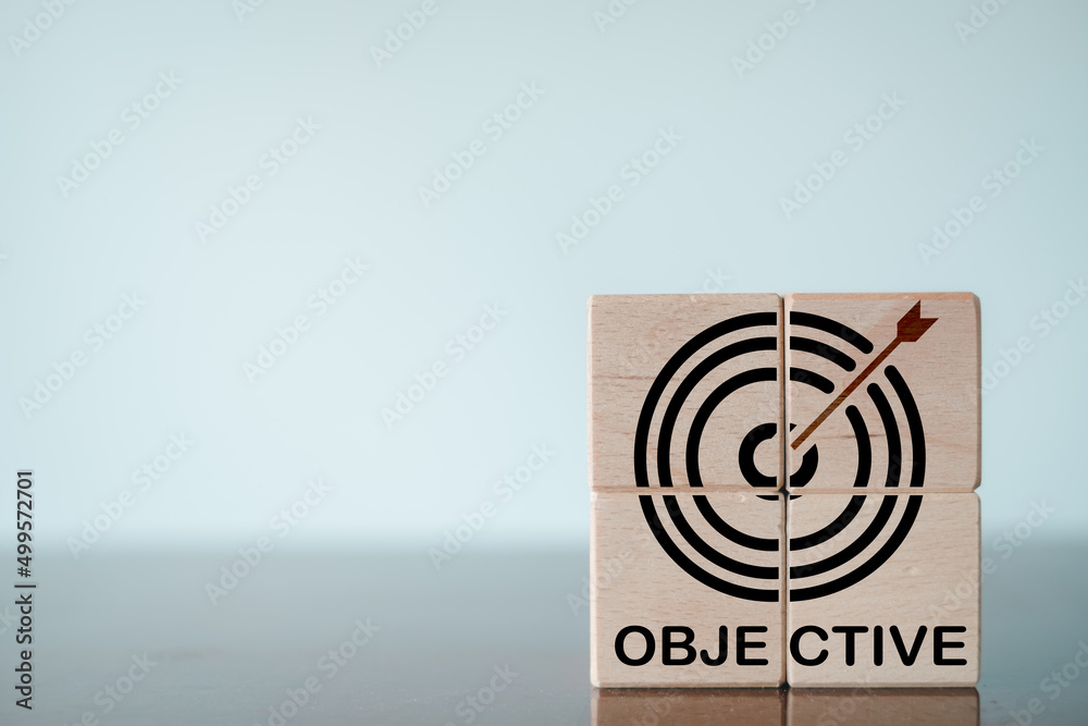 Business Achievement,Target,Objective,Goal Concept.,Target board icon and Objective text on wooden cube over blur white wall background with copyspace. Business Achievement,Target,Objective,Goal Concept.,Target board icon and Objective text on wooden cube over blur white wall background with copyspace.