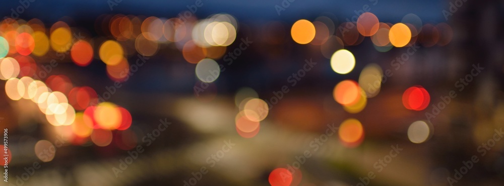 Illuminated city street at night, view from the car. Christmas decorations, lights blurred in bokeh. Cloudscape, aerial view. Holidays, celebration, vacations, staying at home concepts