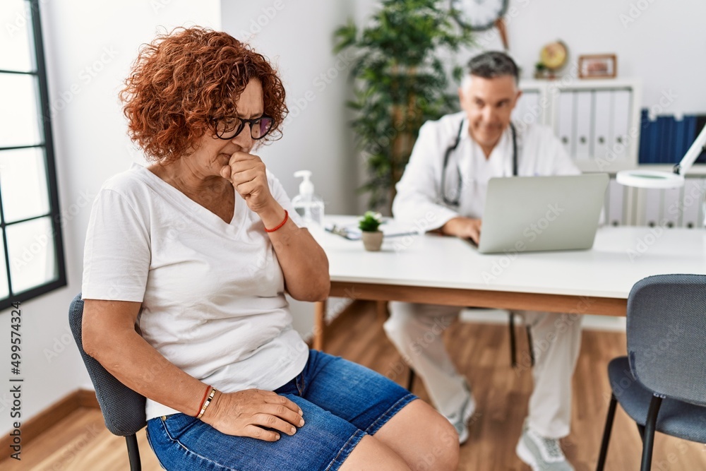 Obraz premium Senior woman sitting at doctor appointment feeling unwell and coughing as symptom for cold or bronchitis. health care concept.