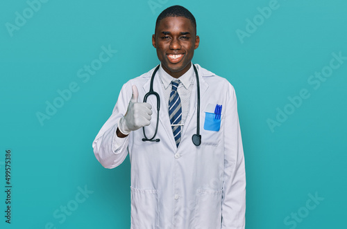 Young african american man wearing doctor uniform and stethoscope smiling happy and positive, thumb up doing excellent and approval sign