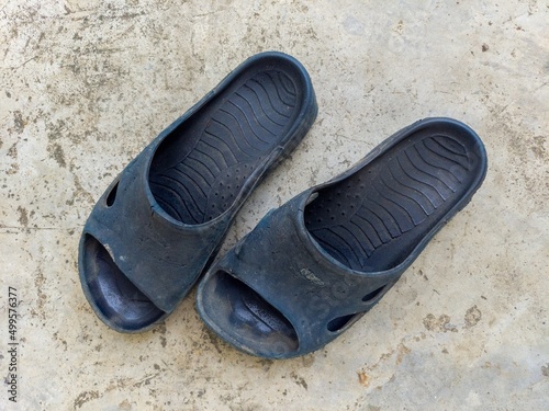 Old slippers on concrete as a background