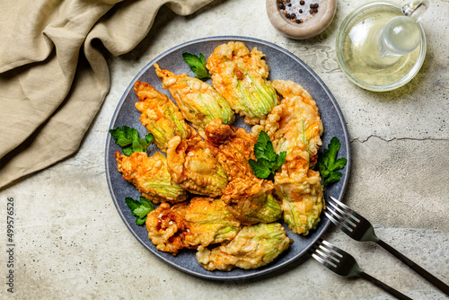 Italian appetizer. Fried in a batter Zucchini Flowers stuffed with ricotta cheese and parsley. Roasted courgette or pumpkin flowers. Fiori di zucca in pastella. Stone background.