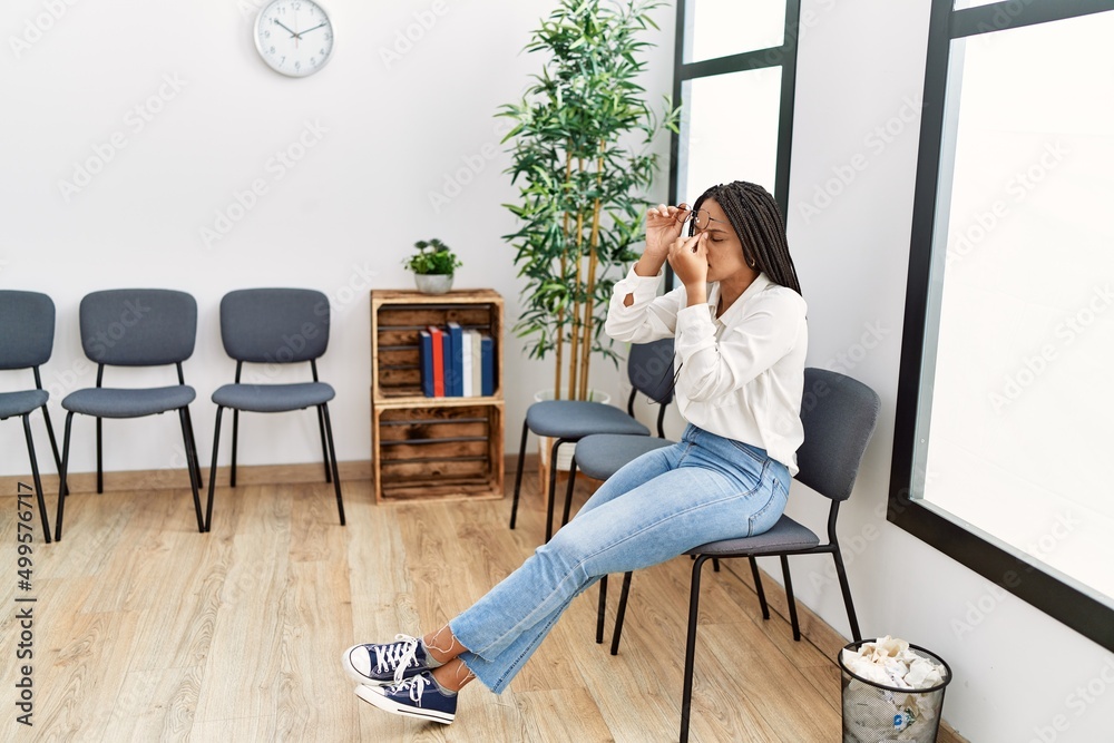 Young african american woman desperate sitting on chair at waiting room Young african american woman desperate sitting on chair at waiting room