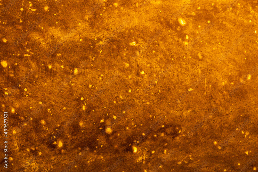 Obraz premium Background Stone wall, golden background with abstract stains of epoxy. Beautiful marble and granite texture, onyx surface. Finishing stone for the interior. Acrylic stains.