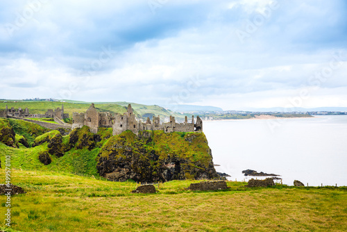 Ruins of Dunluce Castle, Antrim, Northern Ireland during sunny day with semi cloudy sky. Irish ancient castle near Wild Atlantic Way.