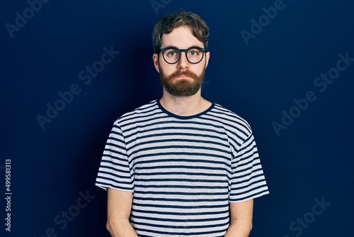 Caucasian man with beard wearing striped t shirt and glasses depressed and worry for distress, crying angry and afraid. sad expression. © Krakenimages.com