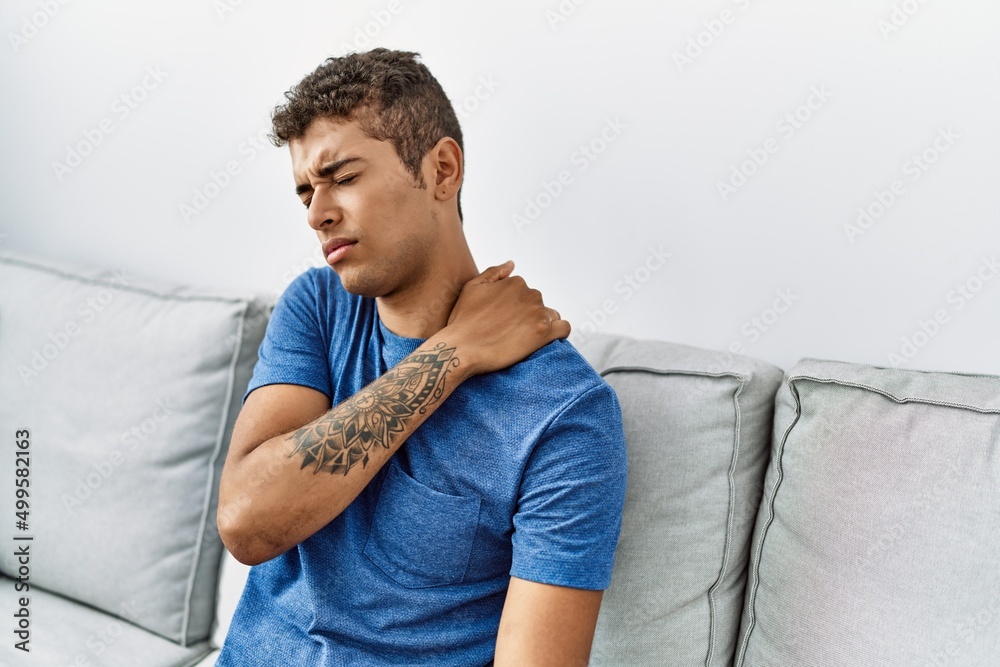 Young hispanic man with neck pain at home Young hispanic man with neck pain at home