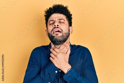 Fototapeta Naklejka Na Ścianę i Meble -  Young arab man with beard wearing casual shirt shouting and suffocate because painful strangle. health problem. asphyxiate and suicide concept.