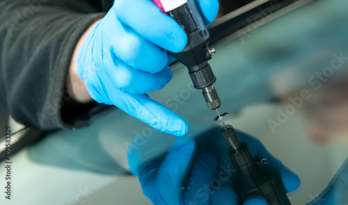 mechanic is repairing an stone chip using his glass repair equipment