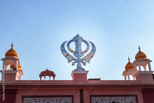 khanda sikh holy religious symbol at gurudwara entrance with bright blue sky photo