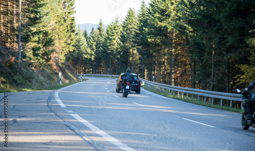 Motorcyclist daringly overtakes a car on a blind road