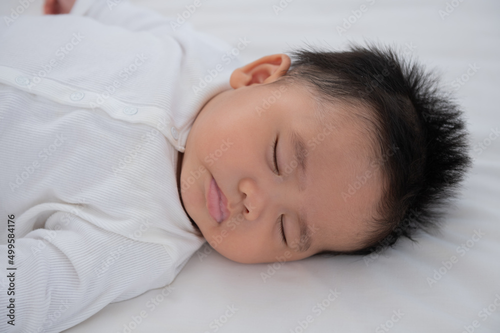 Baby sleeping in bed. Baby boy wearing diaper in white sunny bedroom. newborn child relaxing in bed. nursery for children. textile and bedding for kids. family morning at home. Baby sleeping in bed. Baby boy wearing diaper in white sunny bedroom. newborn child relaxing in bed. nursery for children. textile and bedding for kids. family morning at home.