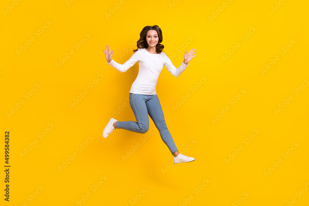 Photo of shiny excited woman wear white shirt jumping high falling isolated yellow color background