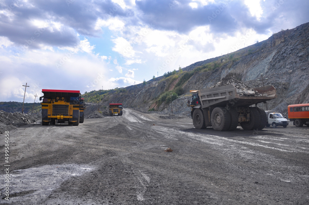 Obraz premium The work of a heavy quarry dump truck in the iron ore quarry.