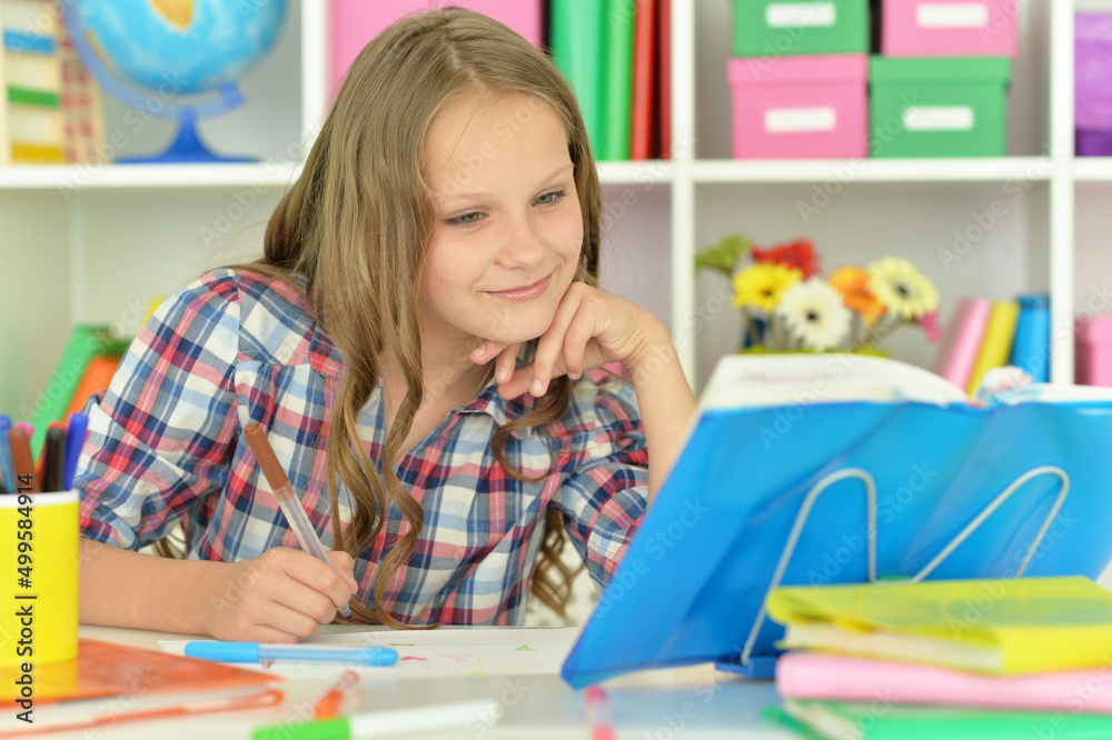 cute girl doing her home work at desk cute girl doing her home work at desk