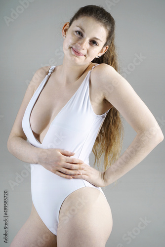 Obraz na płótnie Woman posing in white swimsuit in studio w salonie