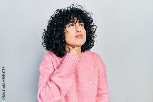 Young middle east woman wearing casual clothes touching painful neck, sore throat for flu, clod and infection