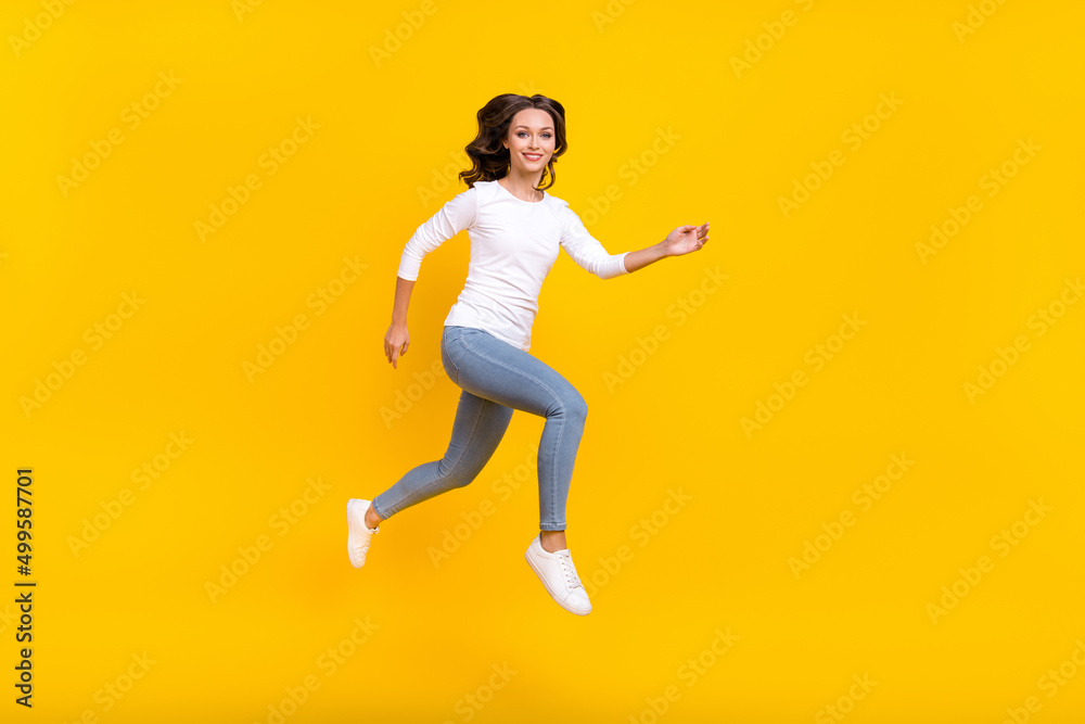 Photo of adorable pretty woman wear white shirt jumping high running fast isolated yellow color background