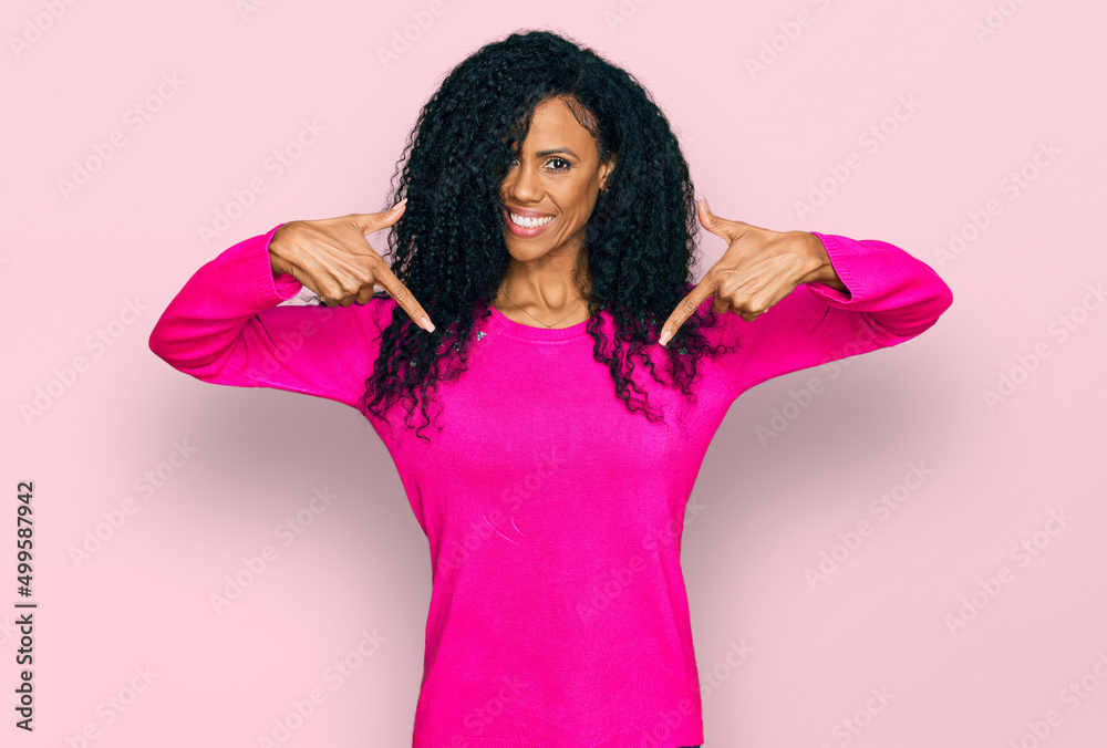 Middle age african american woman wearing casual clothes looking confident with smile on face, pointing oneself with fingers proud and happy. Middle age african american woman wearing casual clothes looking confident with smile on face, pointing oneself with fingers proud and happy.