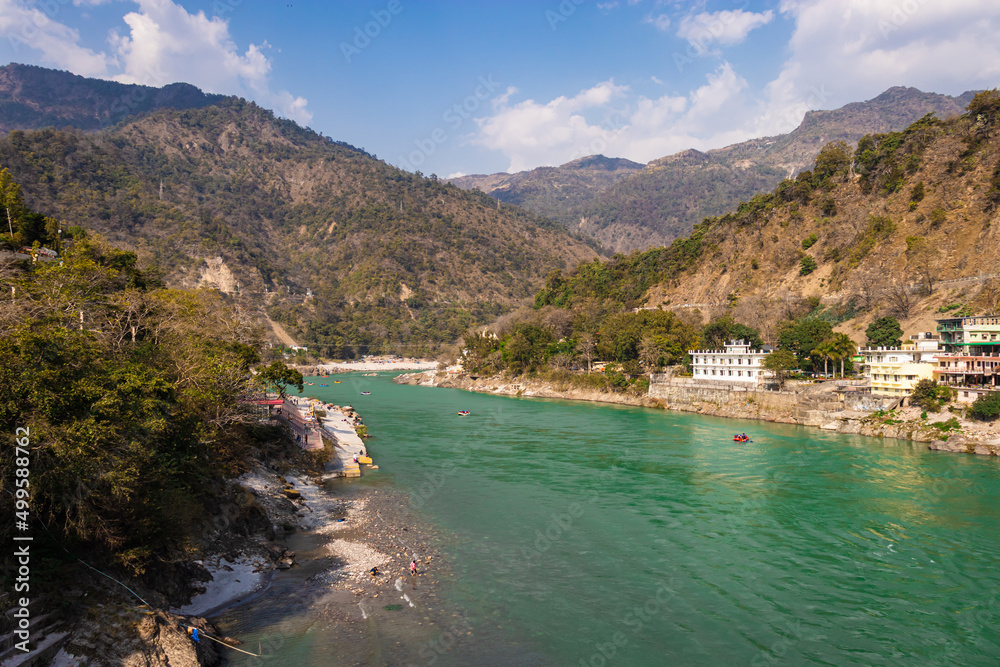ganges river flowing through mountains with city nestled at riverbank from top angle