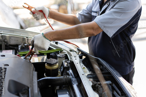 Close up and Selective focus of car mechanic holding battery electricity cables jumper for charging car battery, Services car engine machine concept