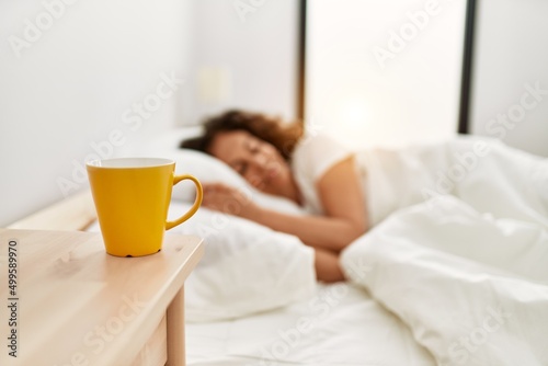 Fototapeta Middle age hispanic woman sleeping on the bed at bedroom