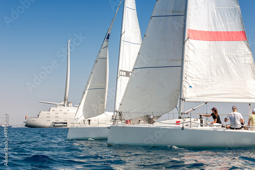 Sailboats near Cyprus coast, super yacht in background © kirill_makarov
