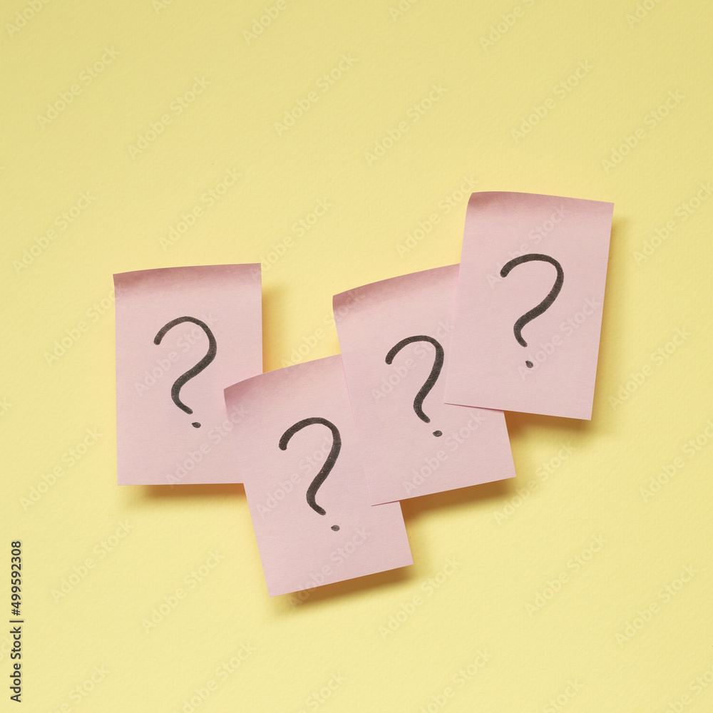 Question mark on pink memo paper on yellow background