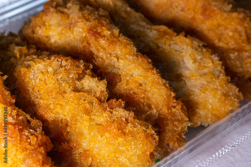A pack of Japanese fried chicken tenders on the table. Takeout fast-food concept image. A pack of Japanese fried chicken tenders on the table. Takeout fast-food concept image.