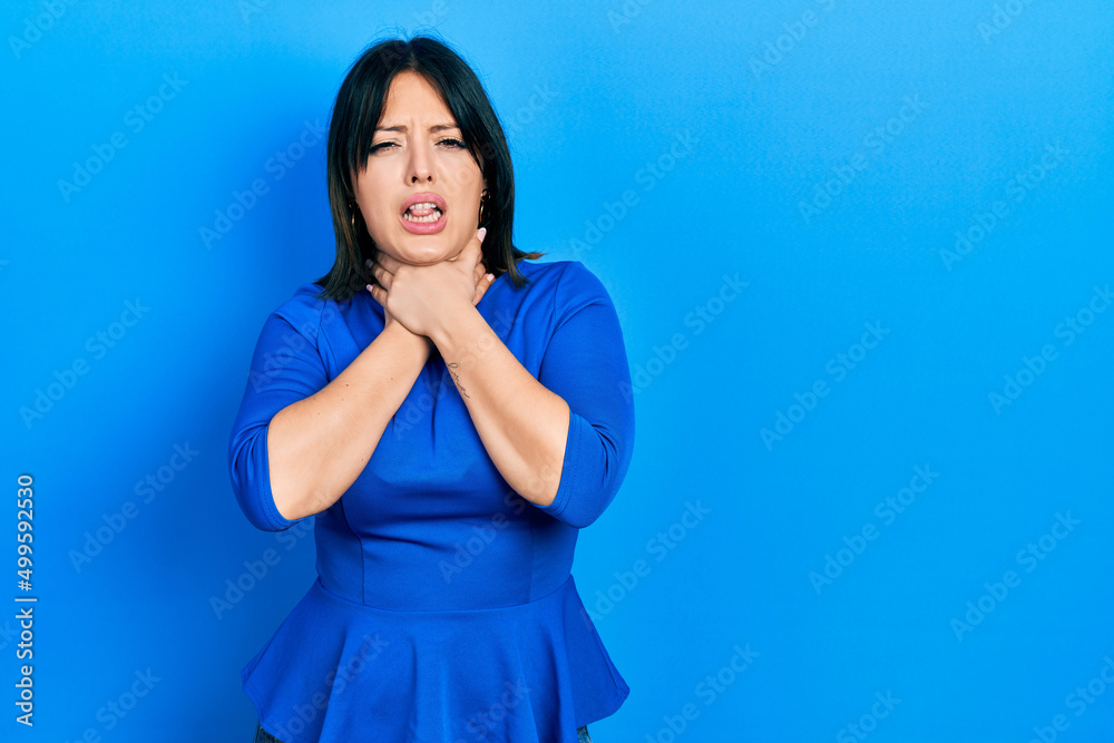 Young hispanic woman wearing casual clothes shouting and suffocate because painful strangle. health problem. asphyxiate and suicide concept. Young hispanic woman wearing casual clothes shouting and suffocate because painful strangle. health problem. asphyxiate and suicide concept.
