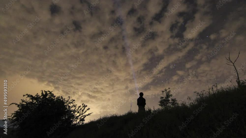Timelapse of a lonely man exploring the wild with a torch in a cloudy night Timelapse of a lonely man exploring the wild with a torch in a cloudy night