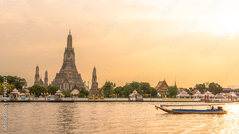 Beautiful sunset landscape photo of Wat Arun temple along Chai Phra Ya river with motor boat during sunset. Arun temple is one famous landmark for tourist around the.world who come to visit Thailand.
