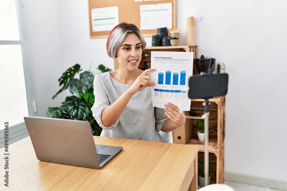 Young caucasian businesswoman smiling happy having video call at the office. Young caucasian businesswoman smiling happy having video call at the office.
