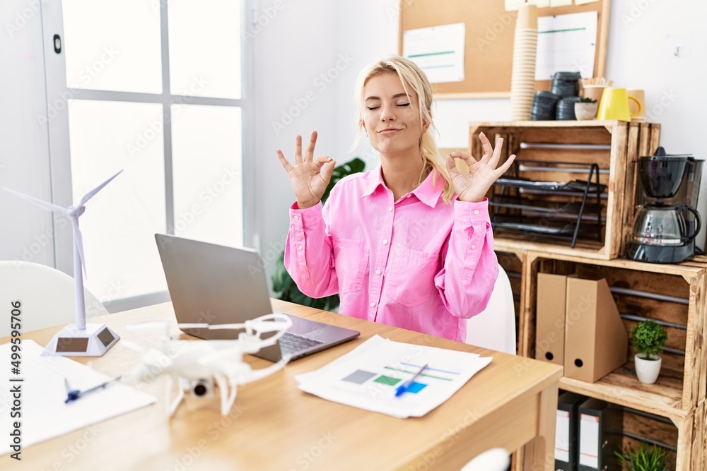 Young caucasian woman working at the office relax and smiling with eyes closed doing meditation gesture with fingers. yoga concept. Young caucasian woman working at the office relax and smiling with eyes closed doing meditation gesture with fingers. yoga concept.