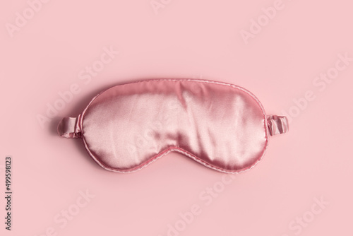 Pink silk sleeping mask on a pastel pink background photo