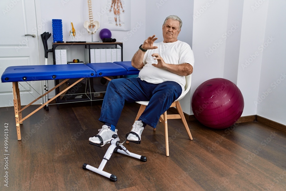 Senior caucasian man at physiotherapy clinic using pedal exerciser disgusted expression displeased and fearful doing disgust face because aversion reaction Krakenimages Foto Poster Wandbilder bei ...