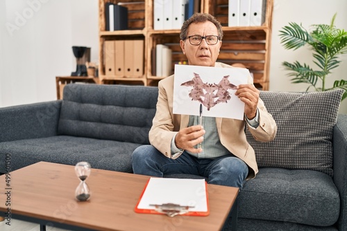 Middle age man having rorscharch test session at clinic photo