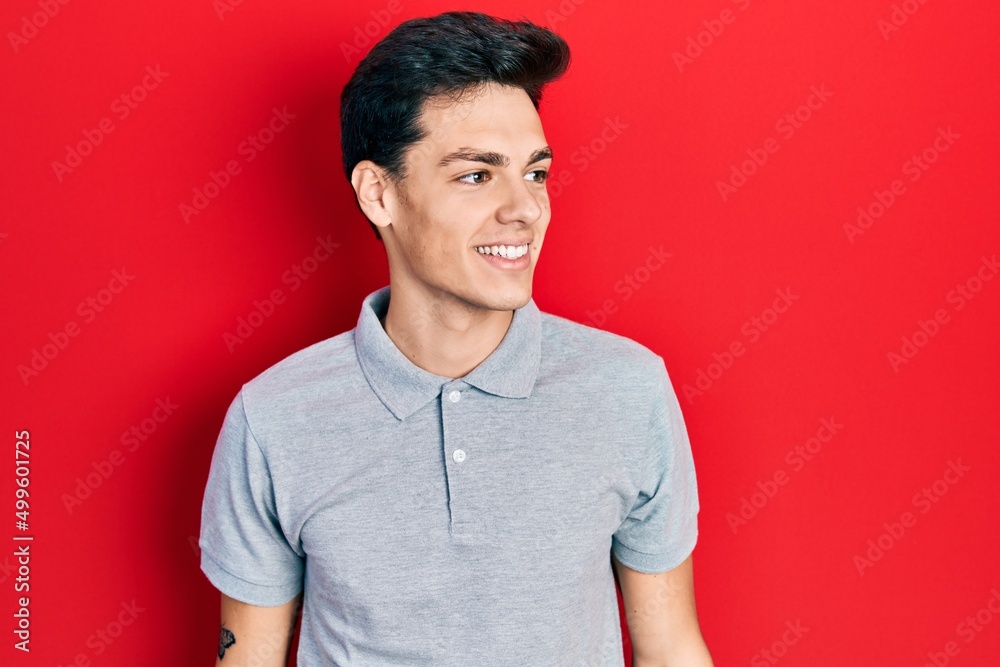 Young hispanic man wearing casual clothes looking to side, relax profile pose with natural face and confident smile. Young hispanic man wearing casual clothes looking to side, relax profile pose with natural face and confident smile.