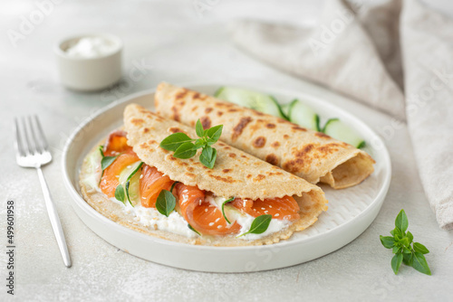 oatmeal pancakes with salted salmon, cucumber, greens and curd cheese