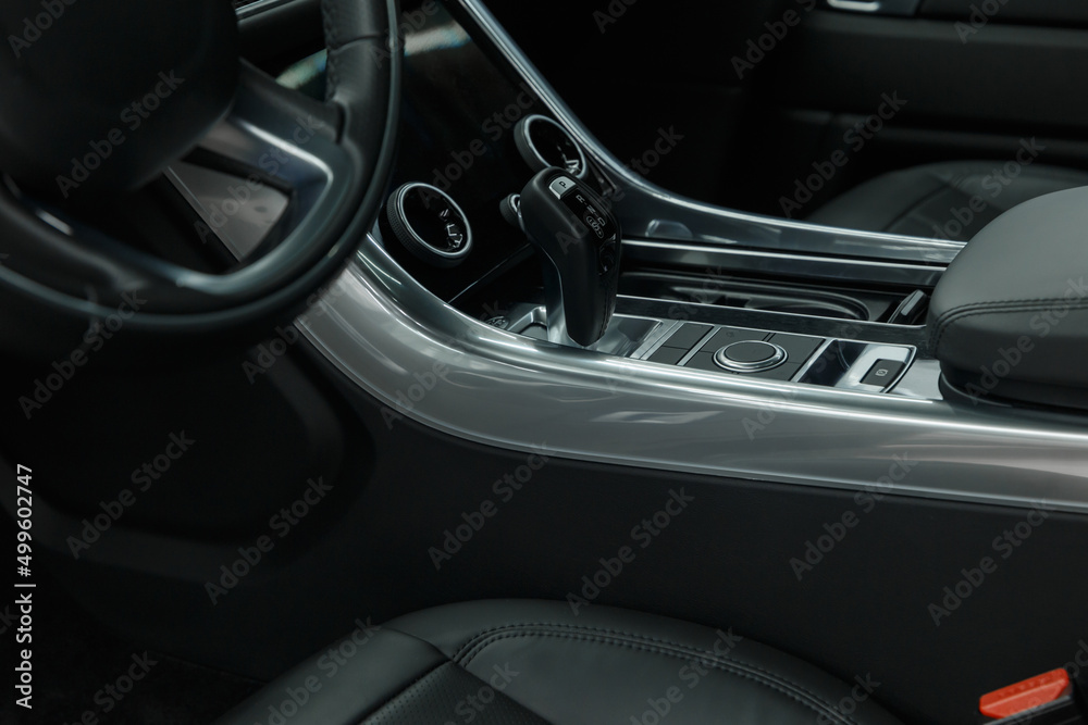 Interior Design of New Car. Automatic gearbox and media controller close up. Elements of a luxury premium sedan. Car air conditioning and climate control. The interior of a modern business class car