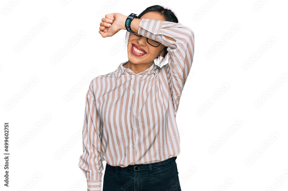 Young hispanic girl wearing casual clothes and glasses covering eyes with arm smiling cheerful and funny. blind concept. Young hispanic girl wearing casual clothes and glasses covering eyes with arm smiling cheerful and funny. blind concept.