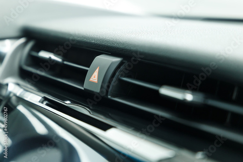 Emergency light stop button in a luxury car. Warning button. Close-up. © Evgenii