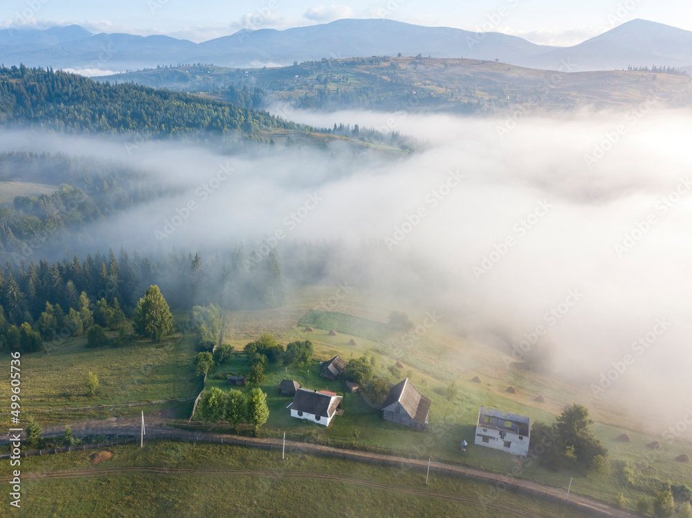 Mountain settlement in the Ukrainian Carpathians in the morning mist. Aerial drone view. Mountain settlement in the Ukrainian Carpathians in the morning mist. Aerial drone view.