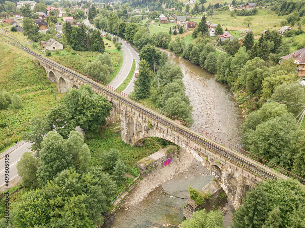 Fototapeta premium Old railway bridge in the mountains. Ukrainian Carpathians. Aerial drone view.