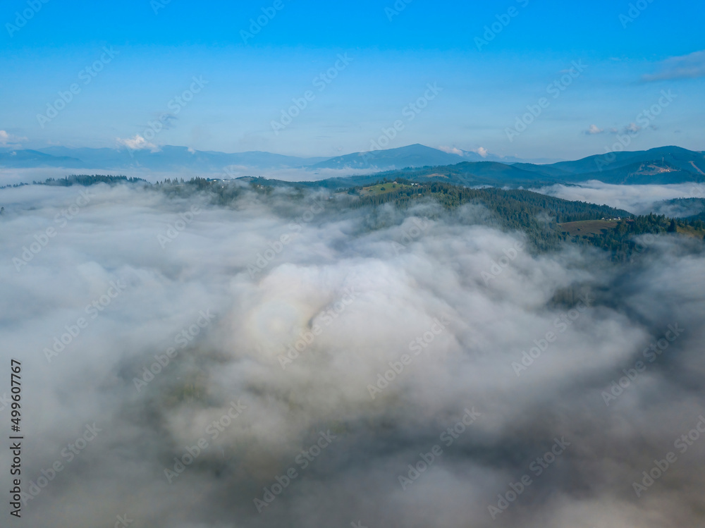 Obraz premium High flight above the clouds in the mountains. Aerial drone view.