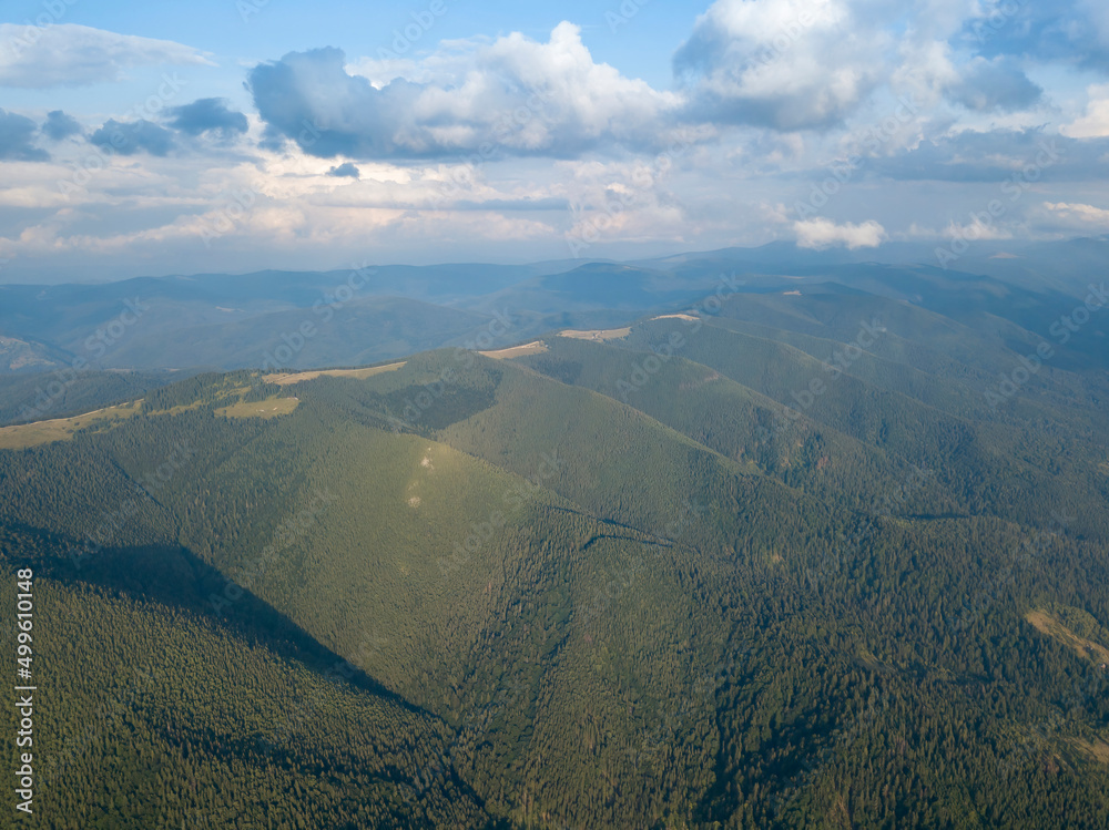 Obraz premium Green slopes of Ukrainian Carpathian mountains in summer. Cloudy day, low clouds. Aerial drone view.