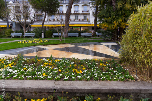 Obraz na płótnie Beautiful colorful flower bed with fountain at riviera of City of Montreux on a cloudy spring day