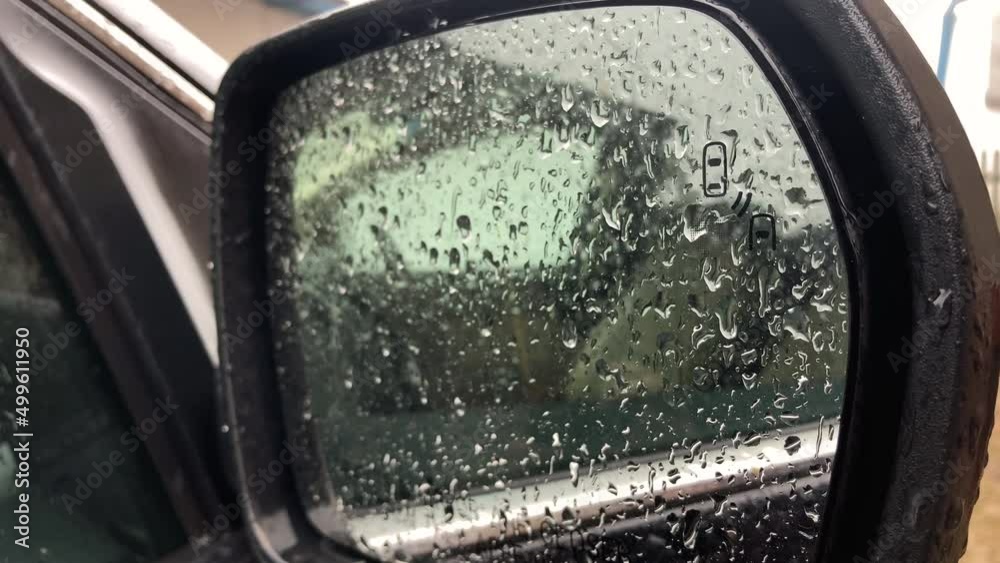 Car side mirror and drivers window with drops of rain sliding down it. Rainy weather. Looking out a car window. High quality 4k footage. High quality 4k footage Car side mirror and drivers window with drops of rain sliding down it. Rainy weather. Looking out a car window. High quality 4k footage. High quality 4k footage