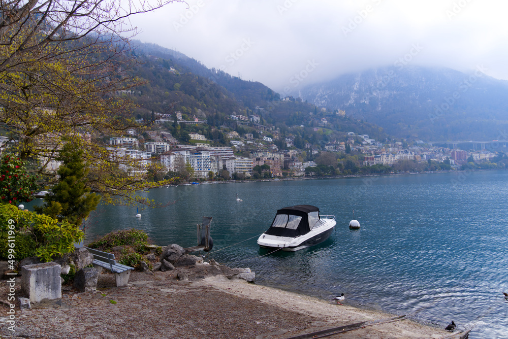 Beautiful view over Lake Geneva seen from Swiss City Montreux, Canton Vaud, on a cloudy spring day with moored motor boat in the foreground. Photo taken April 4th, 2022, Montreux, Switzerland.