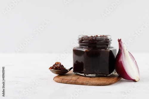 onion marmalade (Onion confiture). onion confit in a glass jar on a white background.